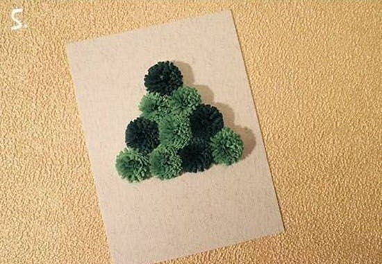 Bước 6. Dùng keo dán, dán những bông hoa giấy để tạo thành hình tam giác có các màu xen kẽ với nhau thành cây thông Noel.