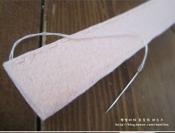 Bước 2. Gấp đôi tấm vải lại dùng kim chỉ khâu cố định mép vải như trên hình hướng dẫn.