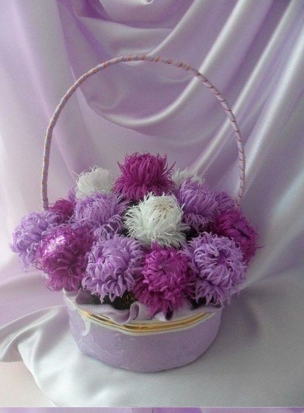 Bước 10. Lần lượt bạn làm thêm nhiêu bông hoa cúc bằng giấy nhún các màu nữa sau đó bạn cắm chúng vào chiếc giỏ đã được chuẩn bị sẵn.