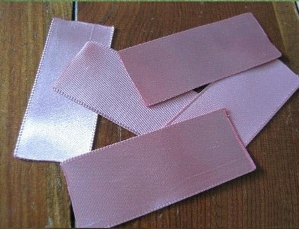 Bước 1. Dây ruy băng hồng bản 4cm bạn cắt lấy 5 đoạn dài khoảng 10cm, dùng lừa hơ cho 2 đầu dải ruy băng k bị xổ ra.