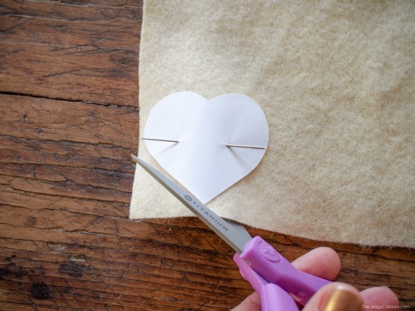 Bước 1. Bạn cắt một hình trái tim mẫu bằng giấy sau đó bạn đặt lên mảnh vải dạ và cắt theo hình mẫu.