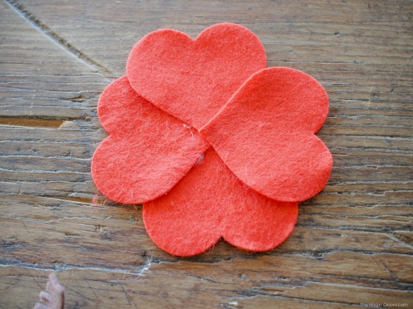 Bước 3. Dùng súng bắn keo dán tùng hình trái tim chồng lên nhau tạo thành hình bông hoa như trên hình.