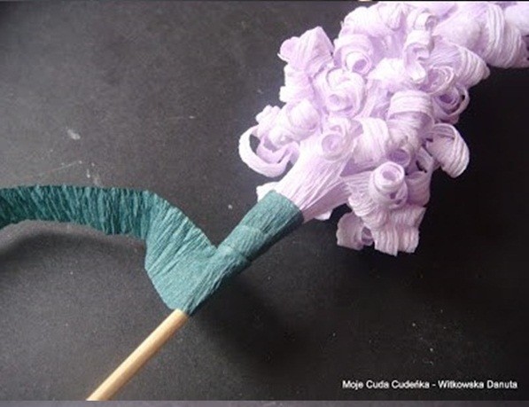 Bước 12. Bạn cắt 1 đoan giấy màu xanh lá cây bạn cuộn tiếp vào phần cuống của bông hoa tiên ông và cuộn tiếp đến hết phần que tre.
