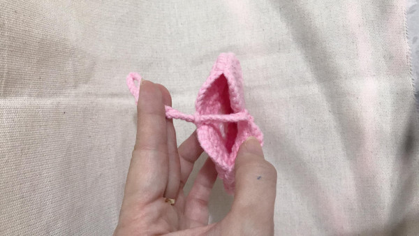Móc túi nhỏ hình hoa năm cánh bằng len màu hồng nhạt.