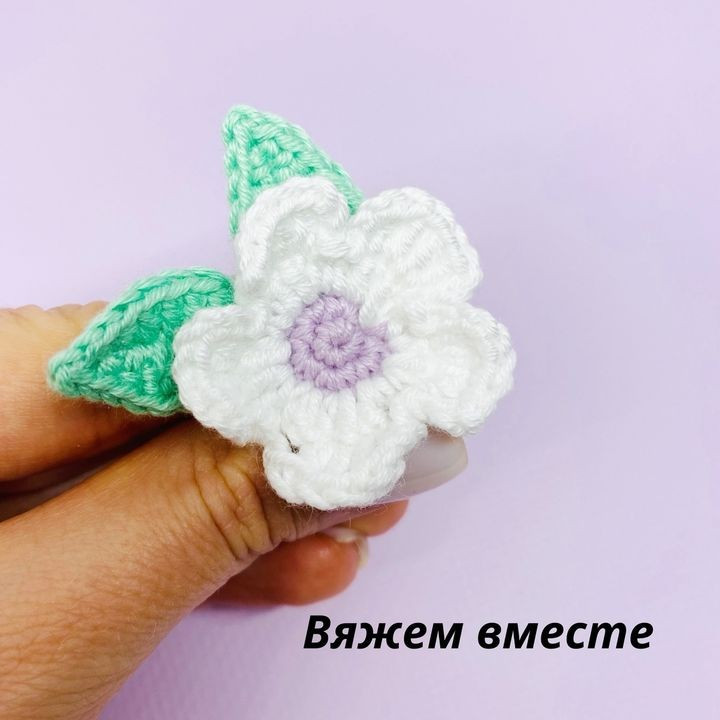 Crochet pattern with five-petaled flowers and green leaves