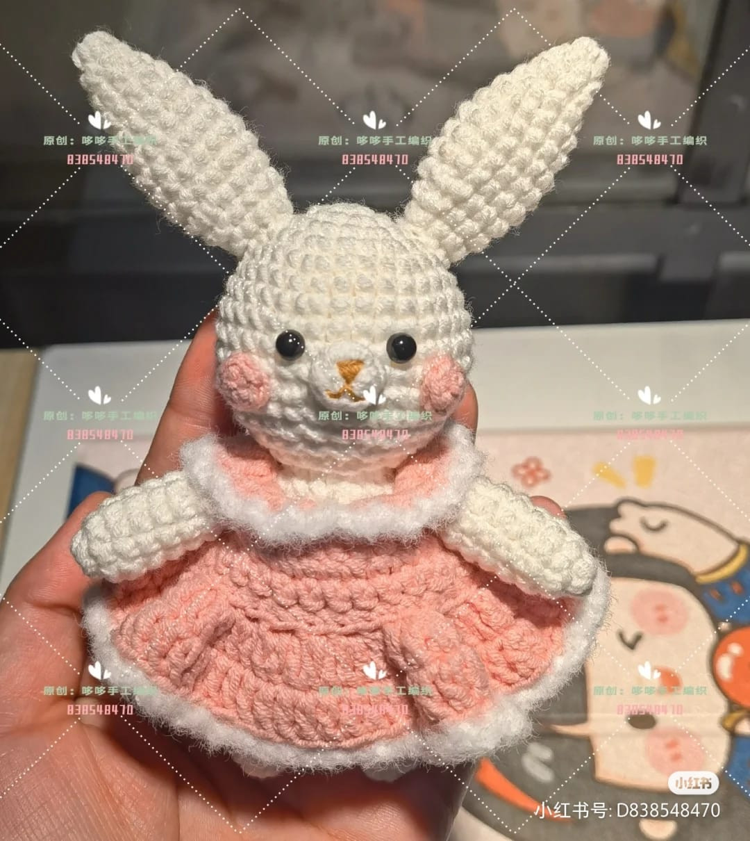 crochet pattern long-eared rabbit wearing a pink skirt over a red coat.