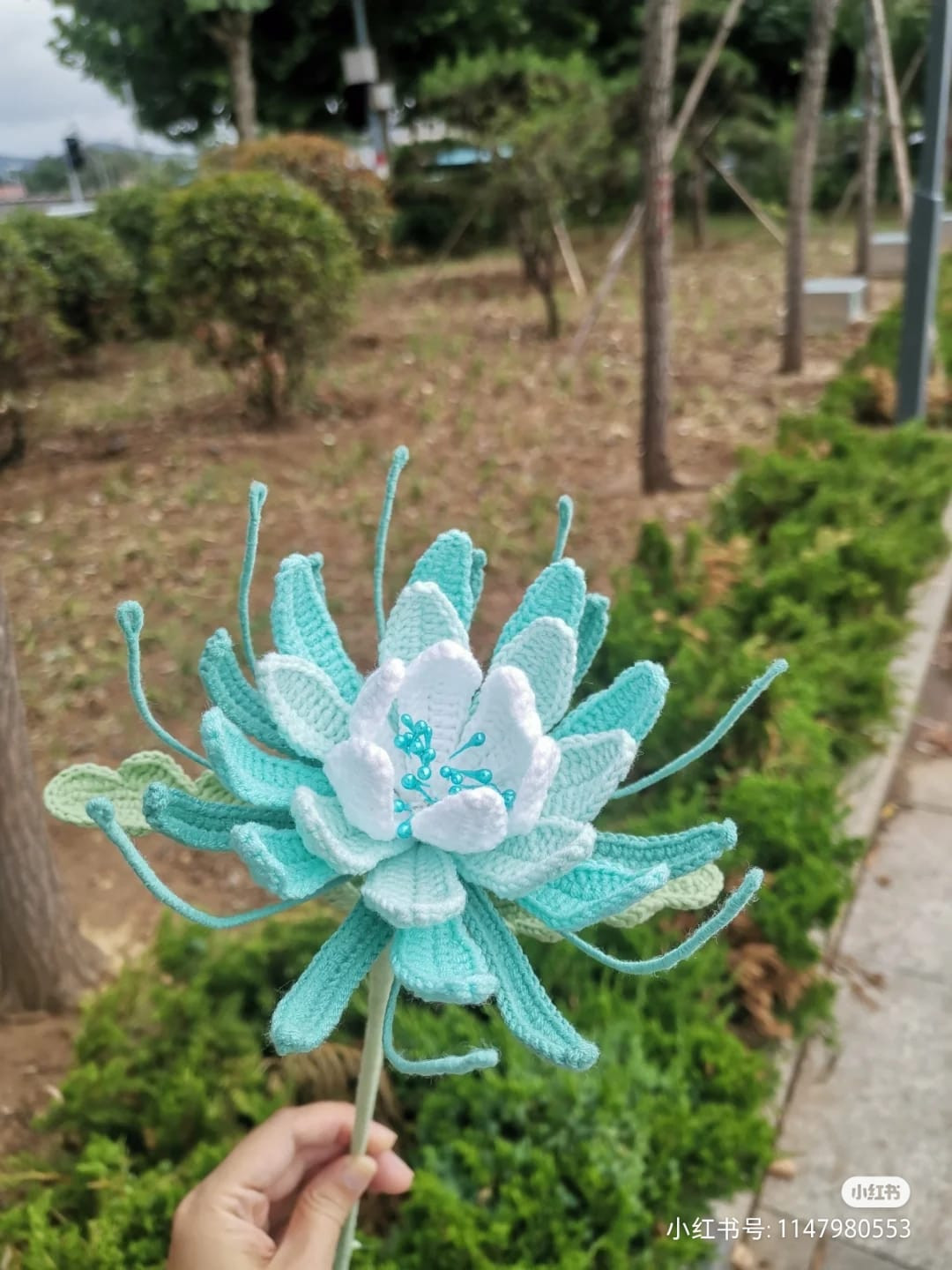 Floral crochet pattern with white petals and blue petals.