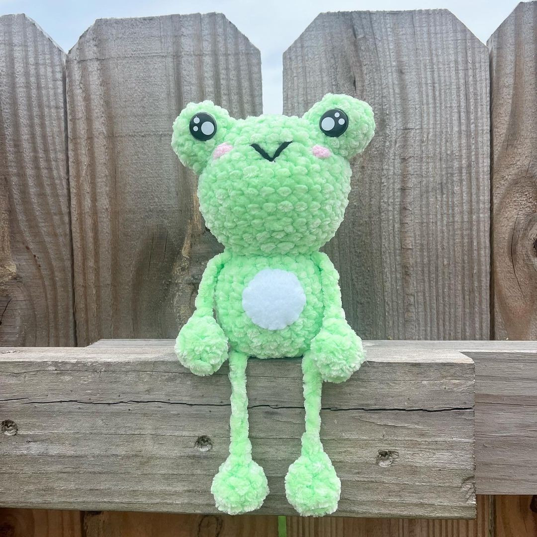 Green frog crochet pattern, bulging eyes, white belly.