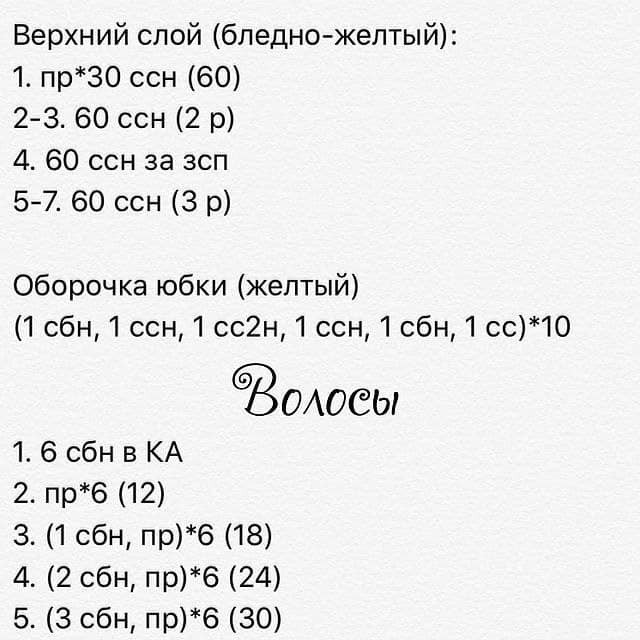 Вязаная крючком кукла с каштановыми волосами, одетая в желтое платье.