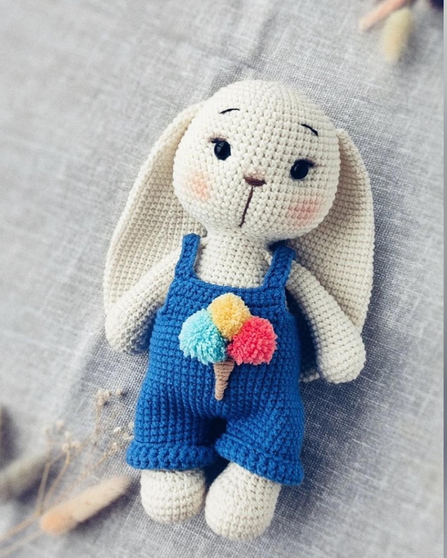 white rabbit, wearing blue overalls, cream cup front crochet pattern