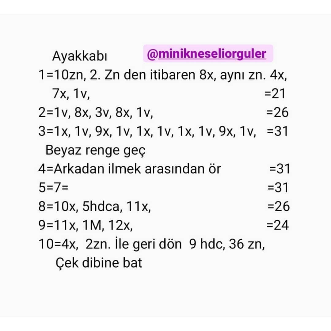 Pembe süslemeli beyaz bir elbise giyen kahverengi saçlı bebek için tığ işi modeli.