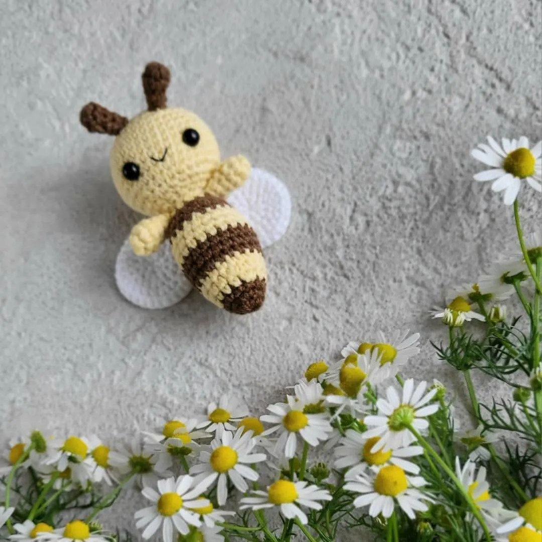 Crochet pattern of bee with white wings and brown stripes