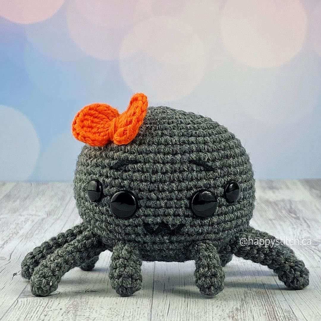 Crochet pattern of gray spider wearing a bow