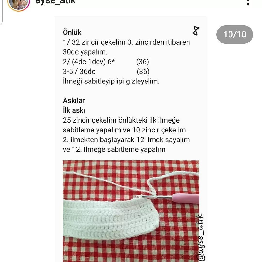 Beyaz bir elbise ve turuncu saç şapkası giyen bir bebek için tığ işi modeli.