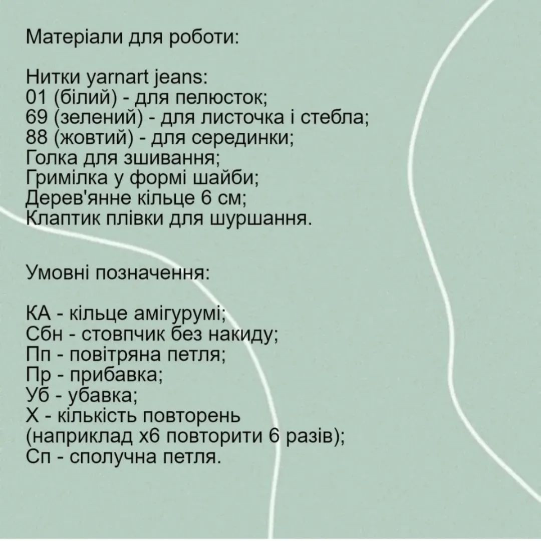 В'язана гачком біла п'ятипелюсткова квітка з жовтою маточкою і зеленим листям