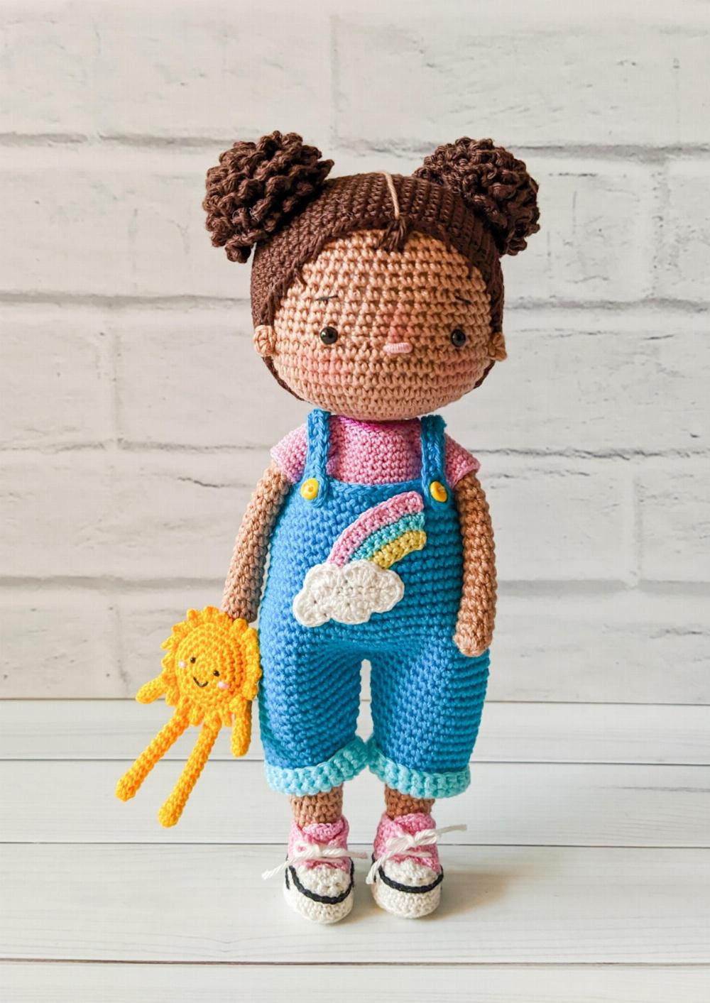 Olivia, Crochet pattern for a girl with her hair in a bun on both sides and wearing overalls