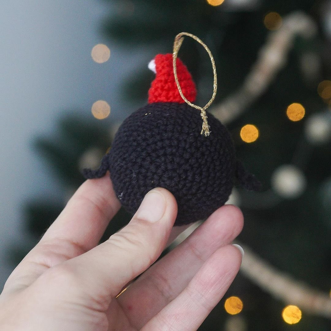 Crochet pattern for a penguin keychain wearing a Christmas hat