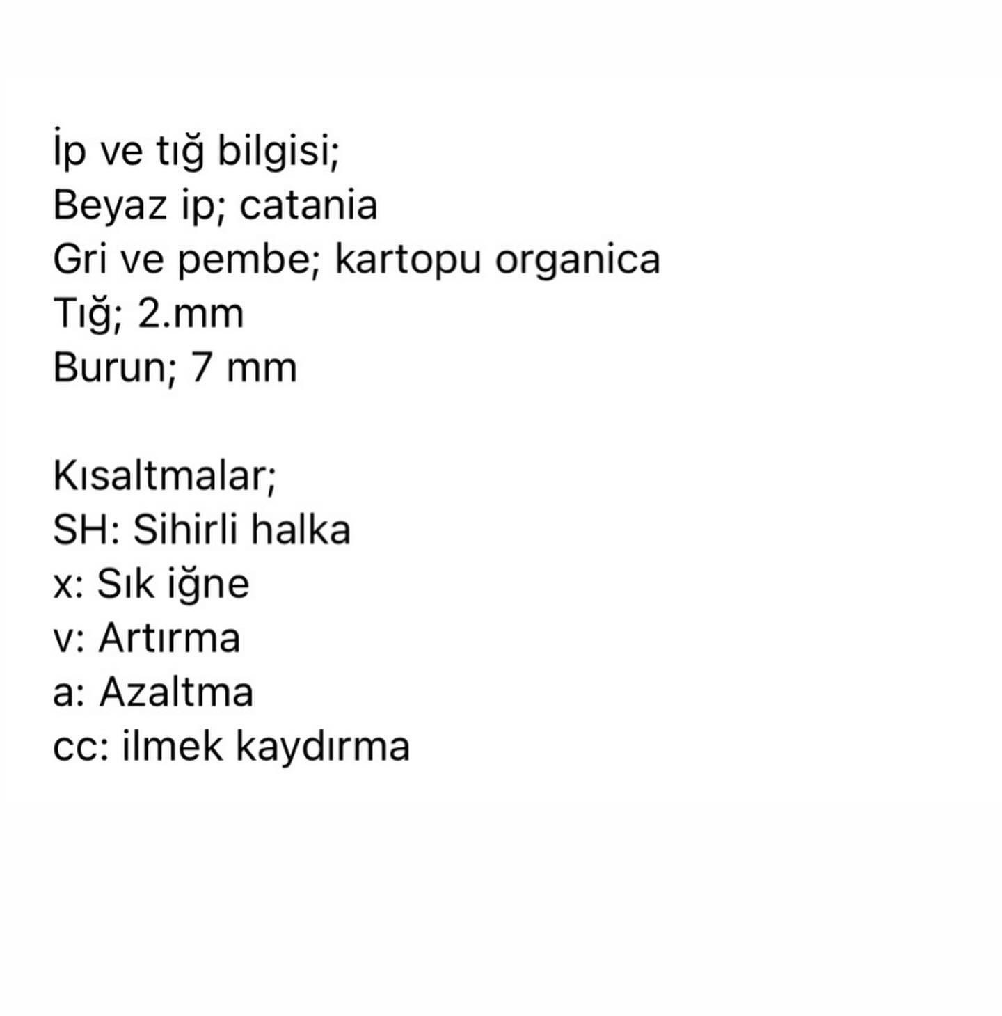 Pembe elbise ve sarı şapka giyen beyaz tavşan tığ işi modeli.