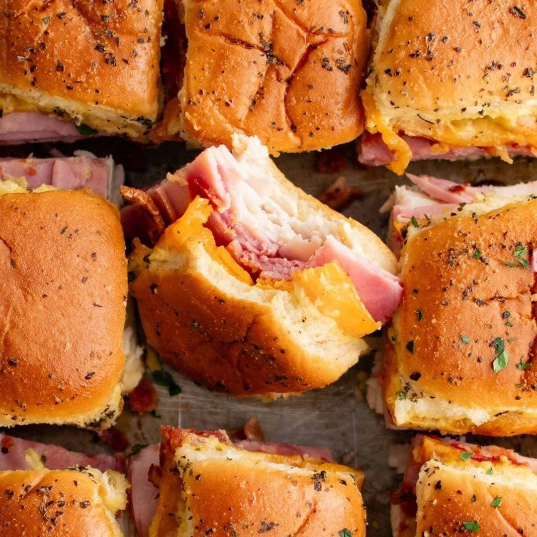 These Baked Club Sliders are super easy to make with layers of deli turkey, ham, and bacon stuffed between Hawaiian Rolls and smothered in garlic herb butter!⁠