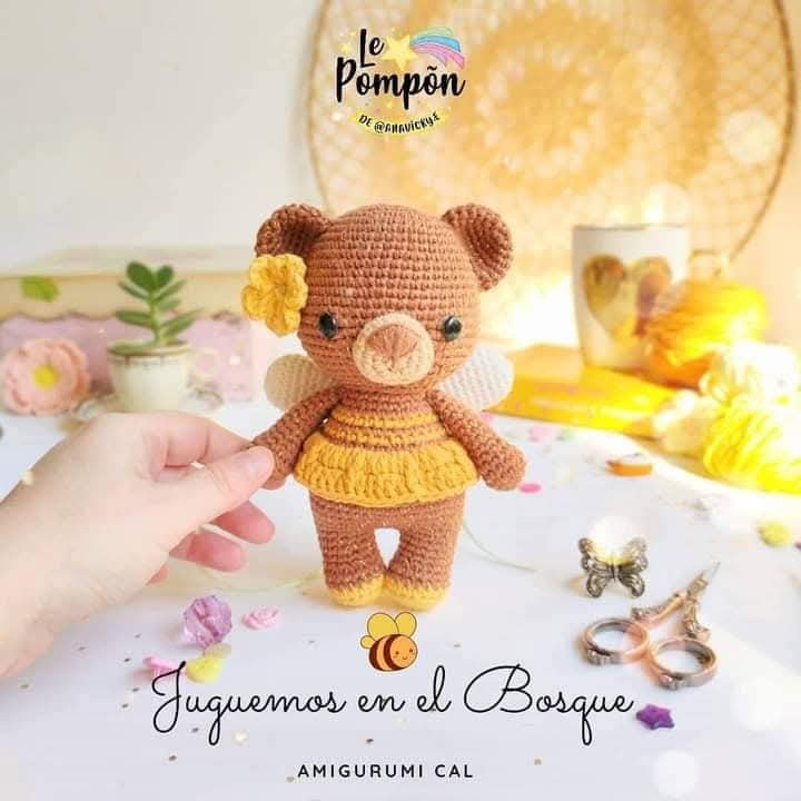 Juguete de oso amigurumi adorable con flores y cánh ong