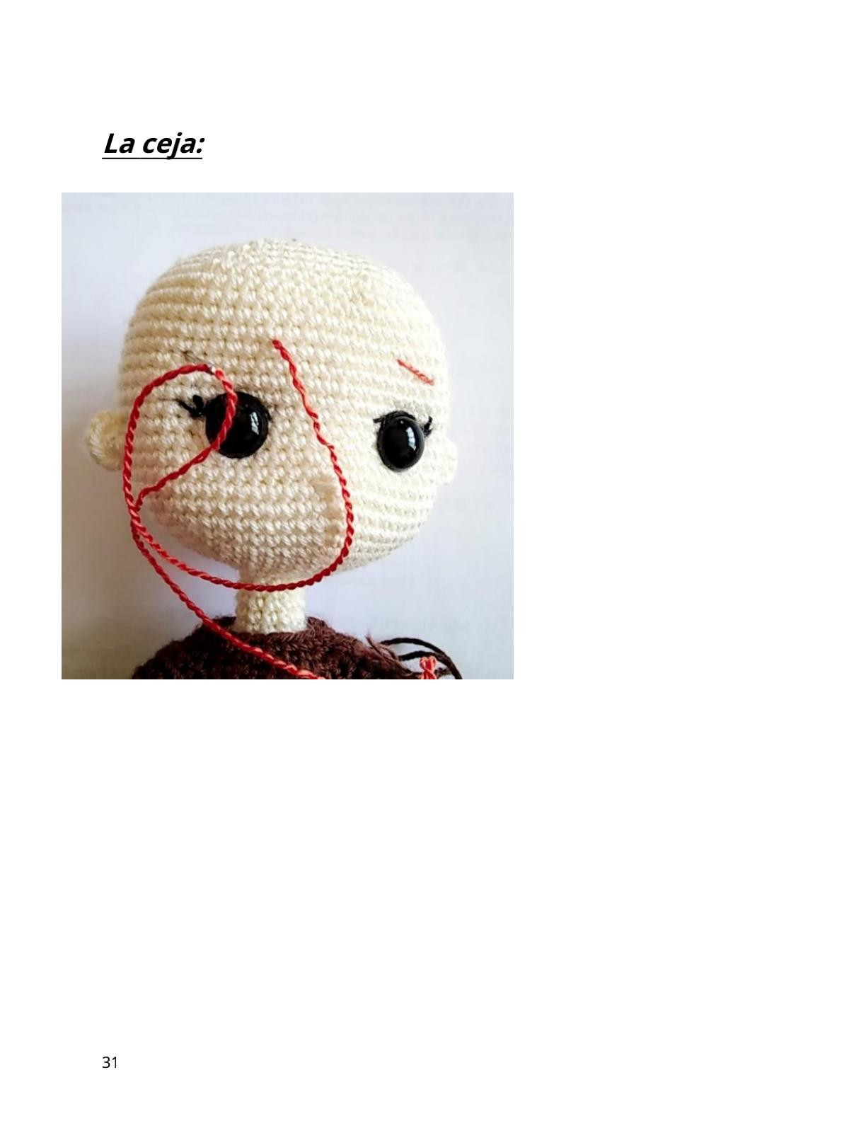 Muñeca amigurumi vestida de azul y rosa con flores.