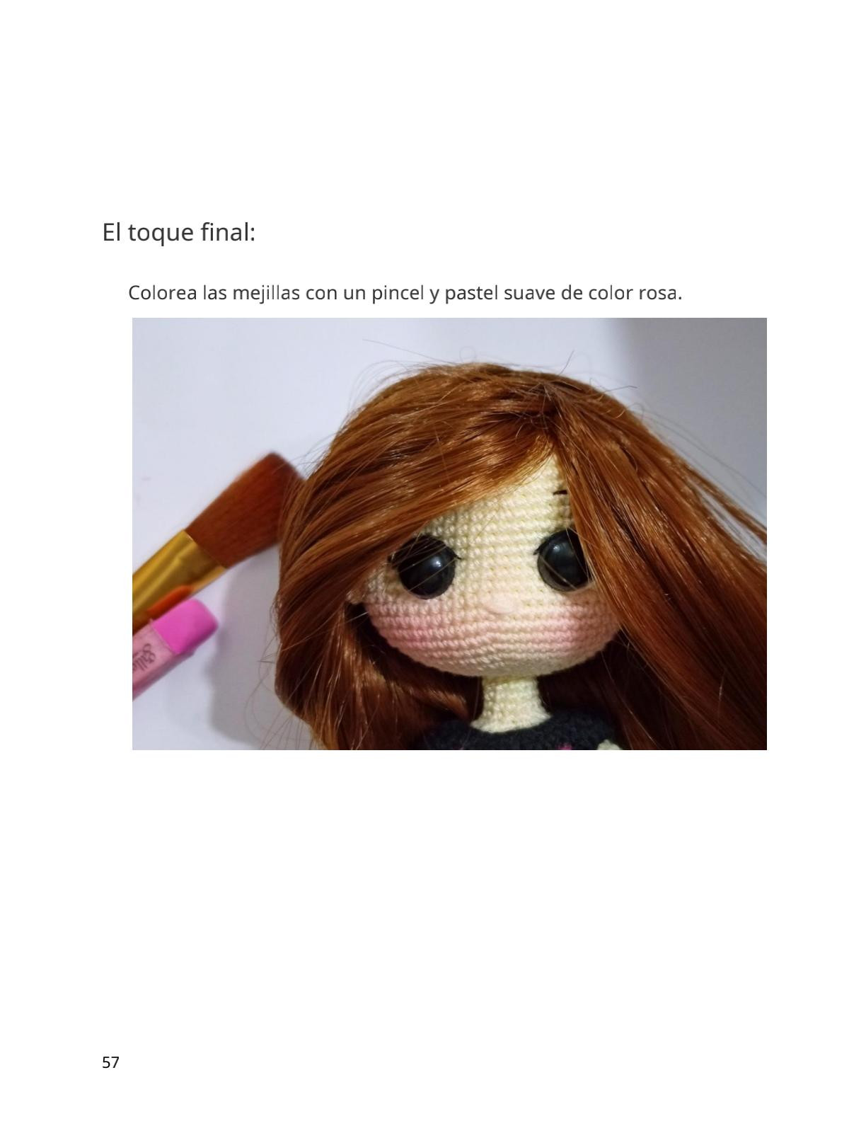 Muñeca amigurumi vestida de azul y rosa con flores.