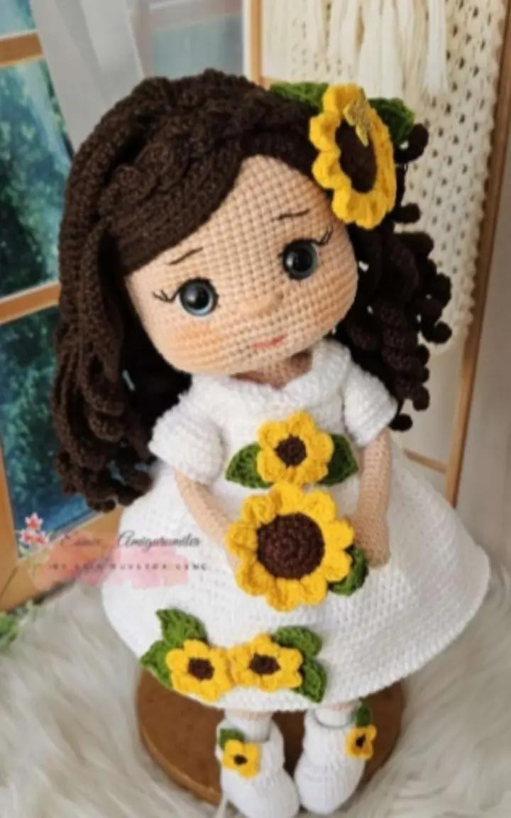 Muñeca de crochet con vestido blanco adornado con girasoles amarillos