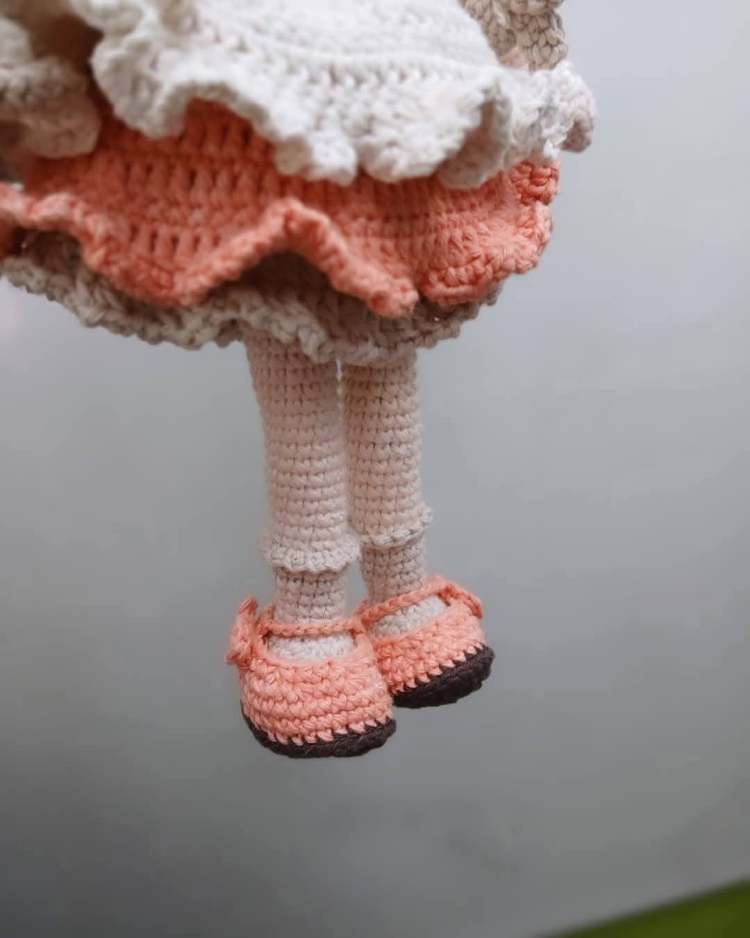 Muñeca de ganchillo con orejas de conejo y vestido colorido