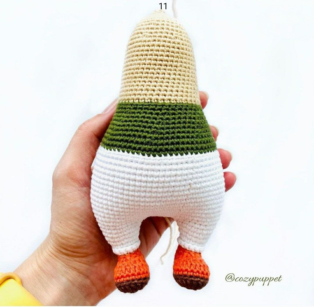 Вязаная игрушка с оранжевыми волосами и зелёной кофточкой