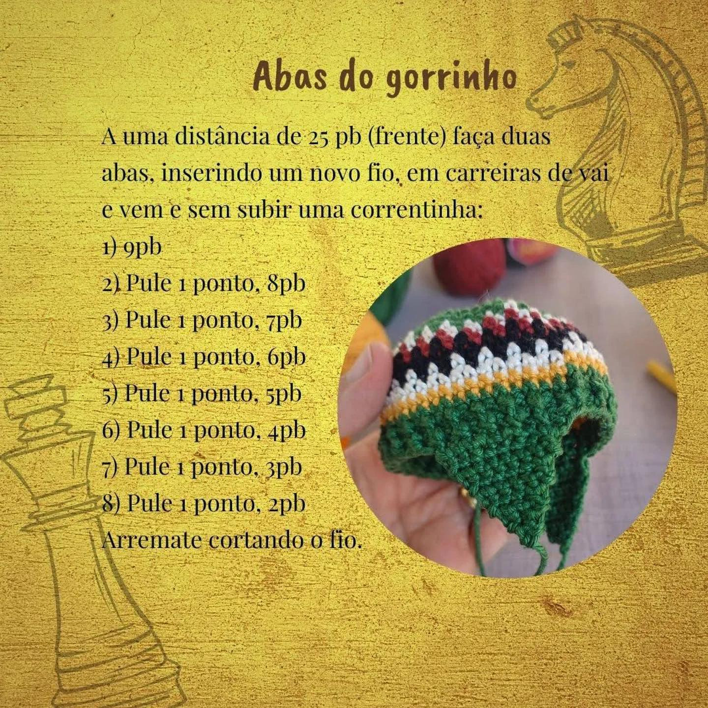 Brinquedo de crochê com chapéu colorido e letra "R" no vestido