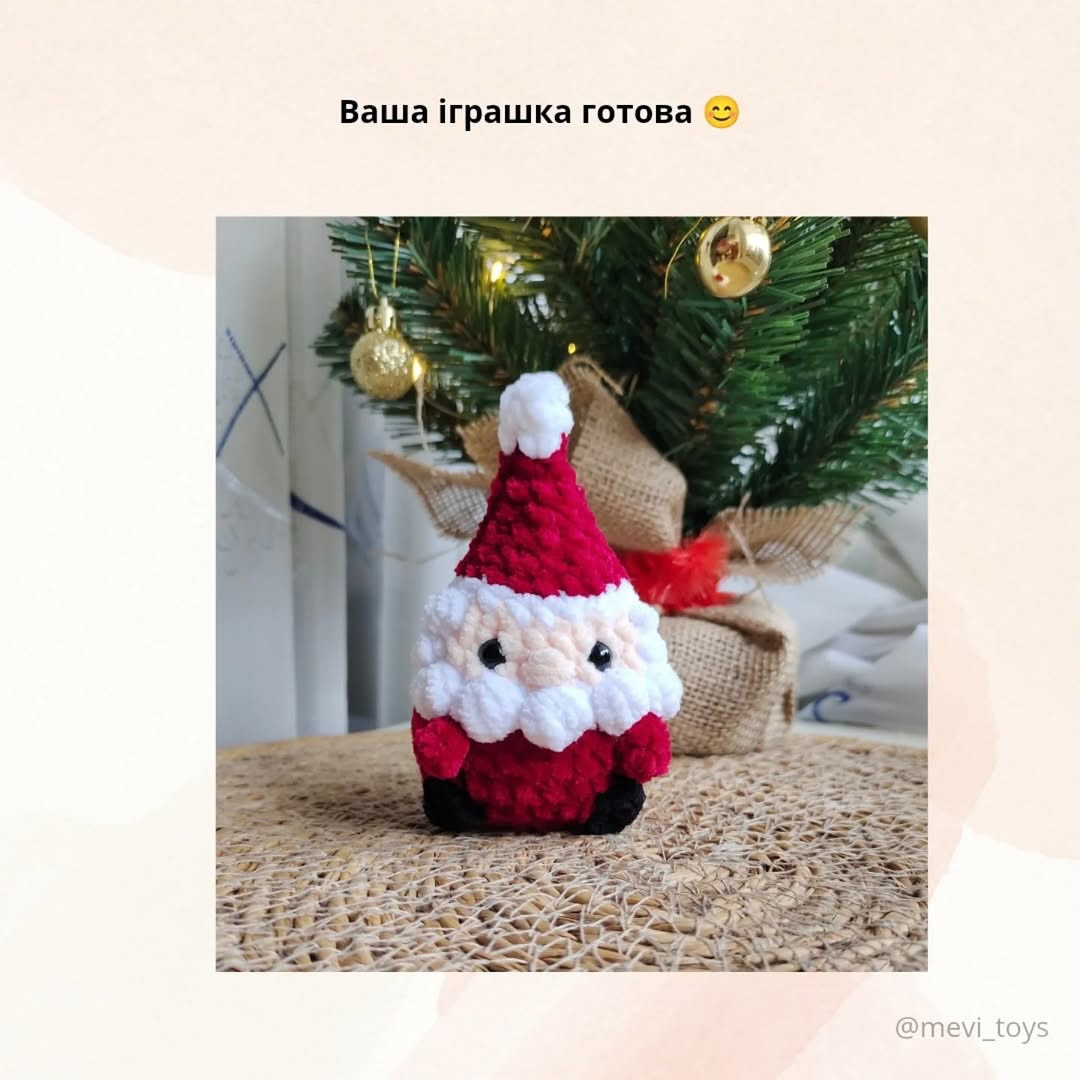 В'язаний Санта Клаус на тлі новорічної ялинки