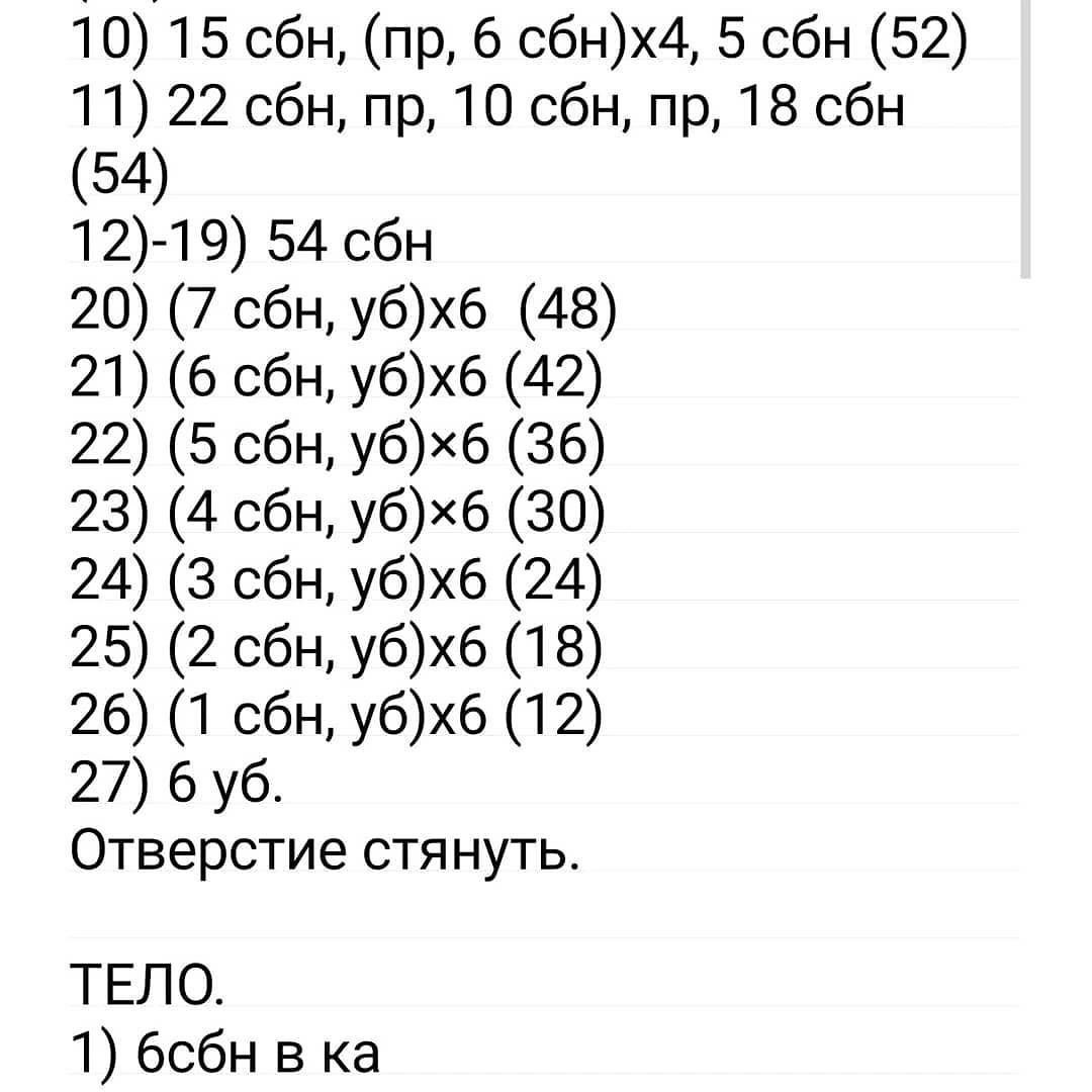 Вязаный мишка в синей пижаме и шапочке готов к сну