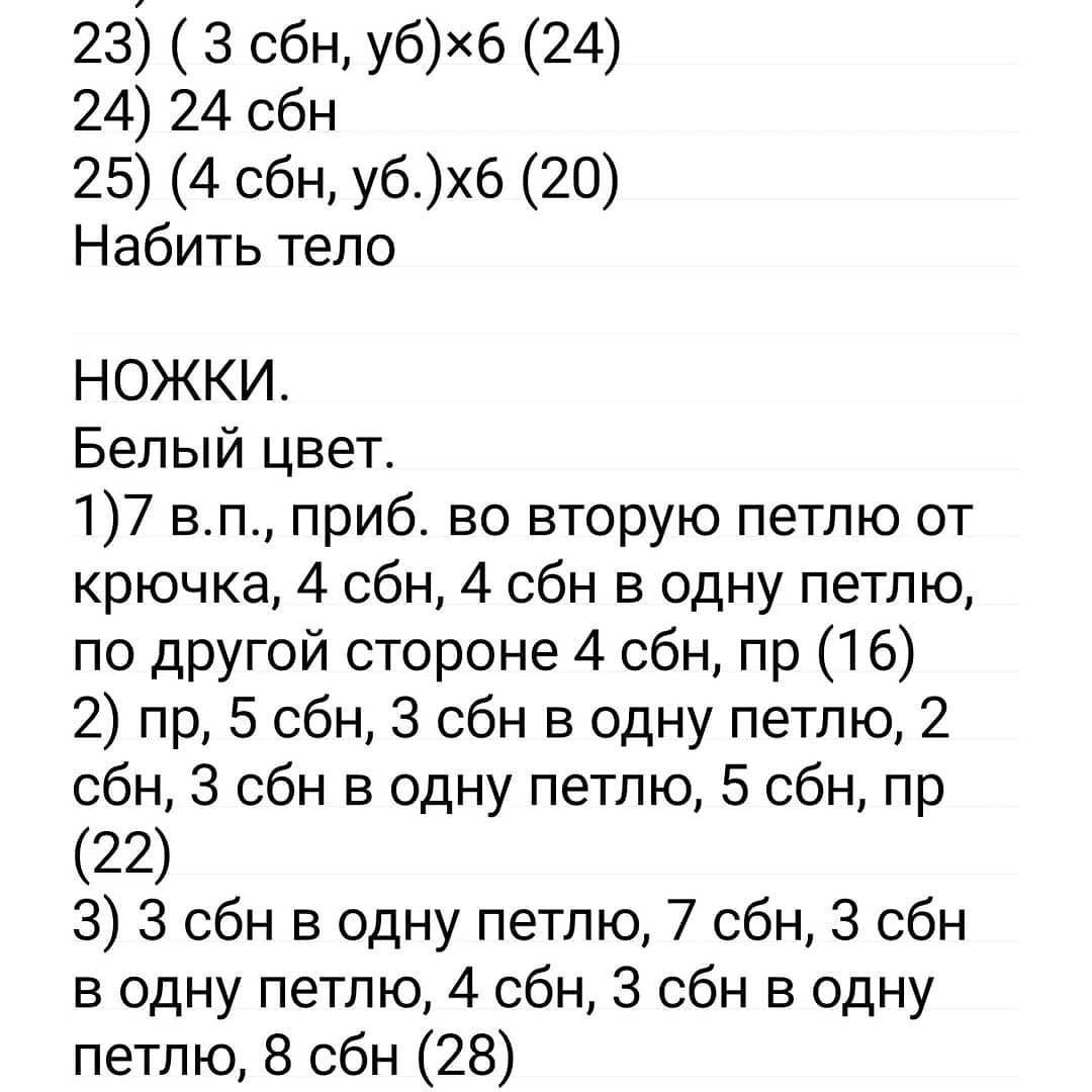 Вязаный мишка в синей пижаме и шапочке готов к сну