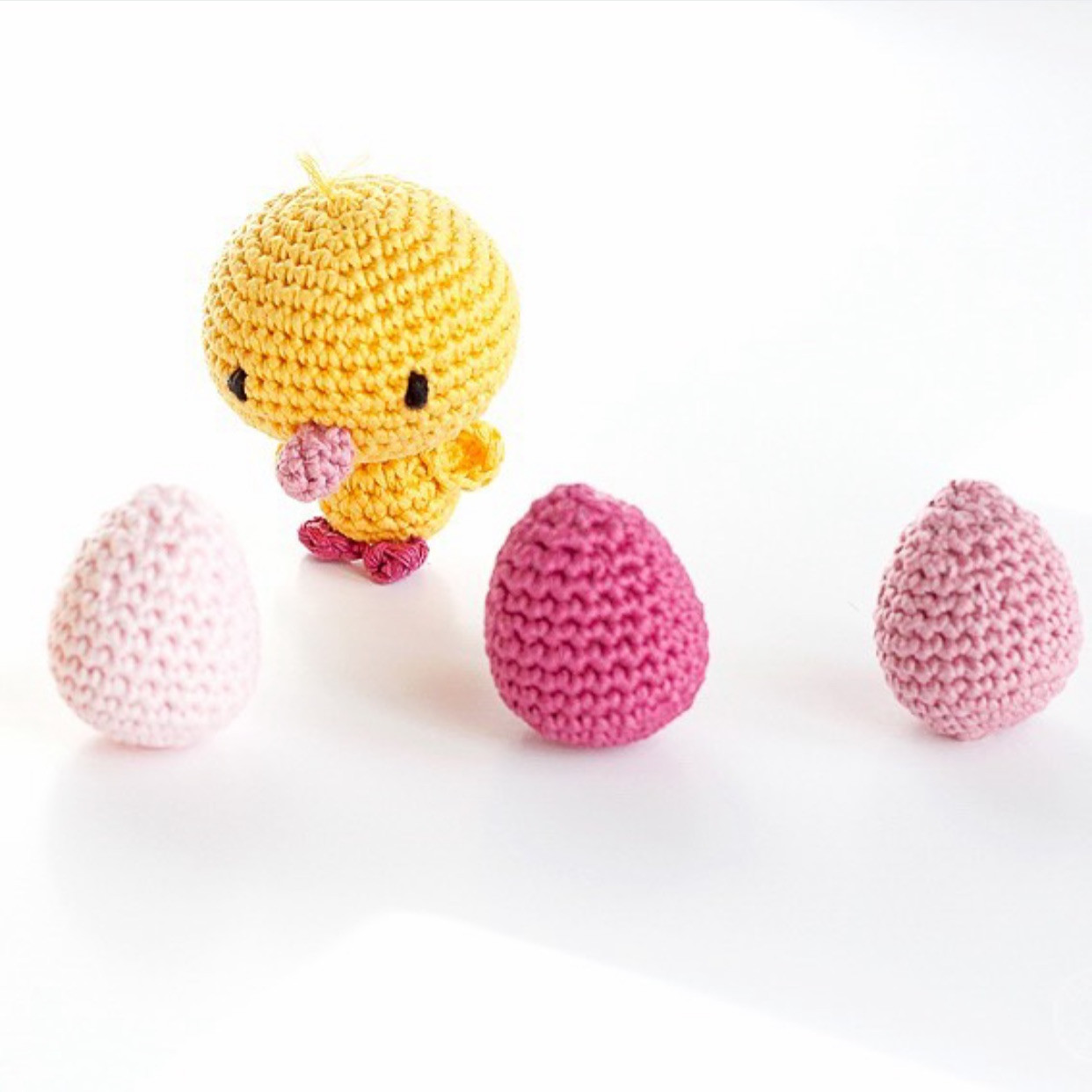 Petit canard en crochet sur une pelote de laine rose
