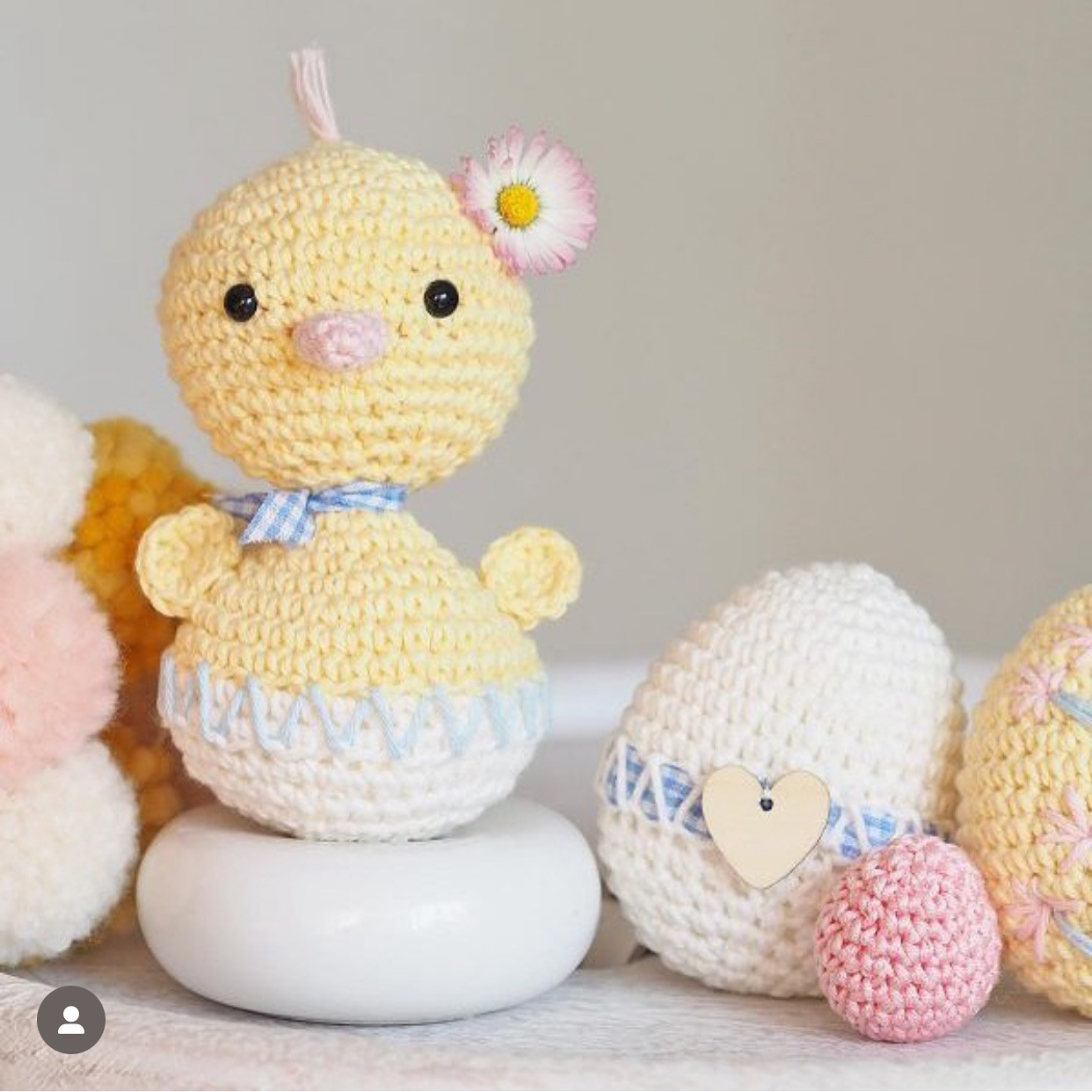 Petit canard en crochet sur une pelote de laine rose