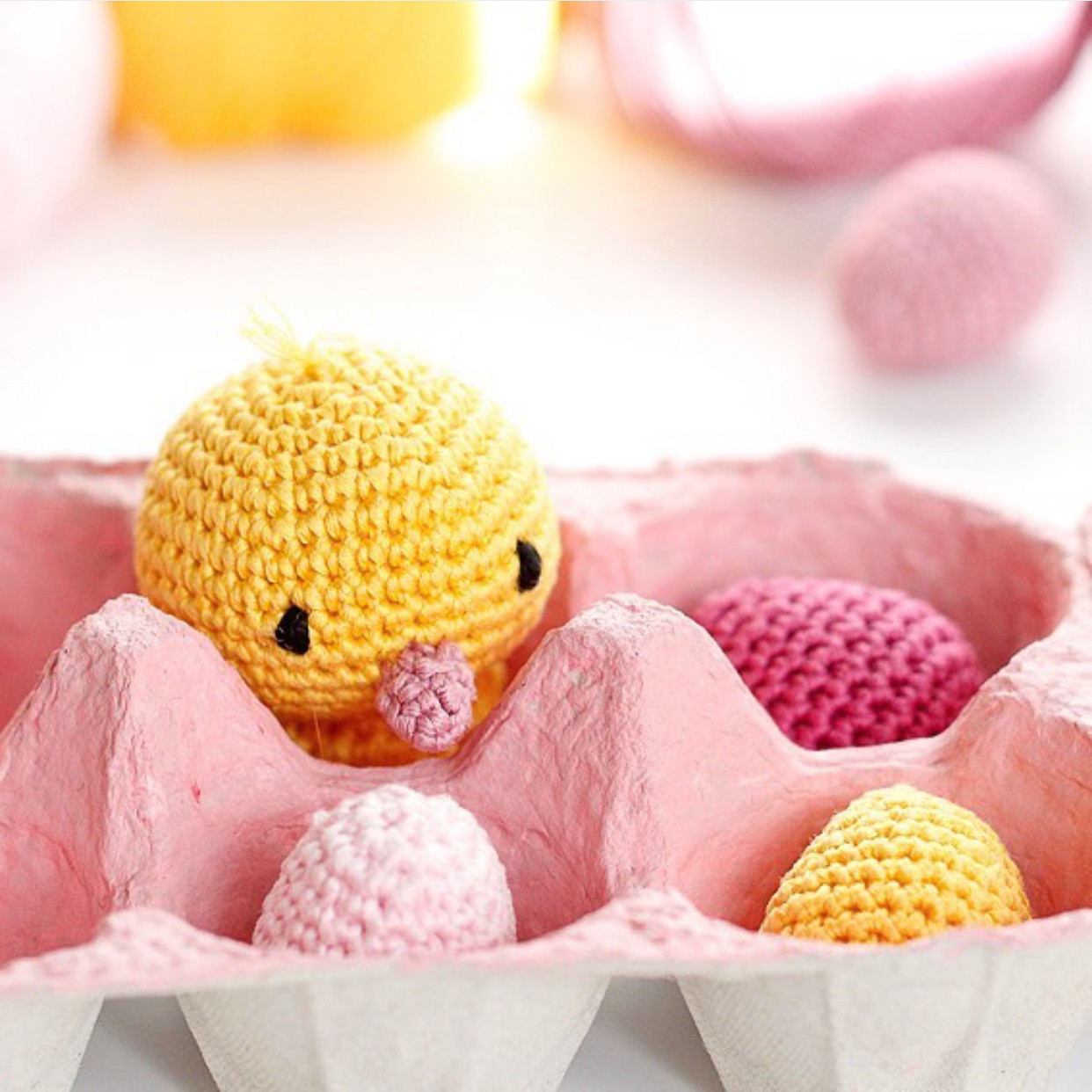 Petit canard en crochet sur une pelote de laine rose