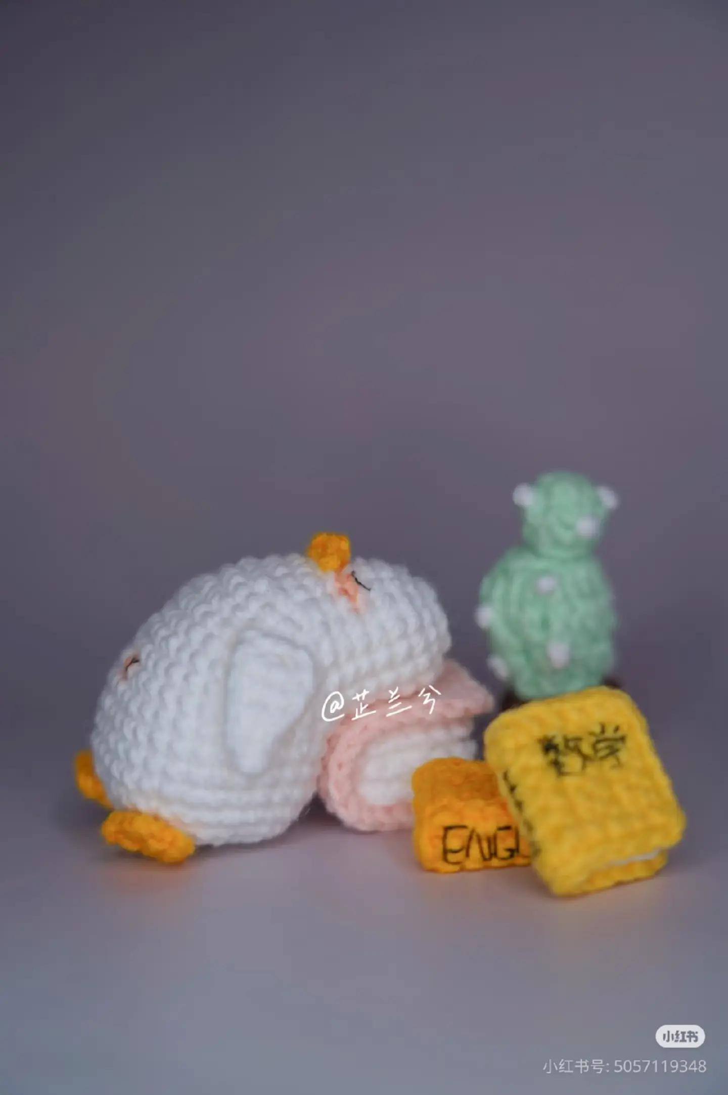 Crochet Penguin Sleeping on Books with Cactus