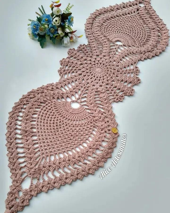 Hermoso camino de mesa de ganchillo en tonos rosas vibrantes