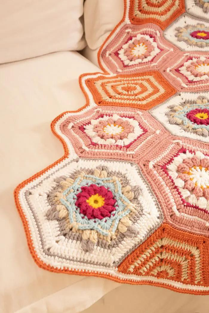 Manta de crochê hexagonal colorida com padrão de flores vibrantes