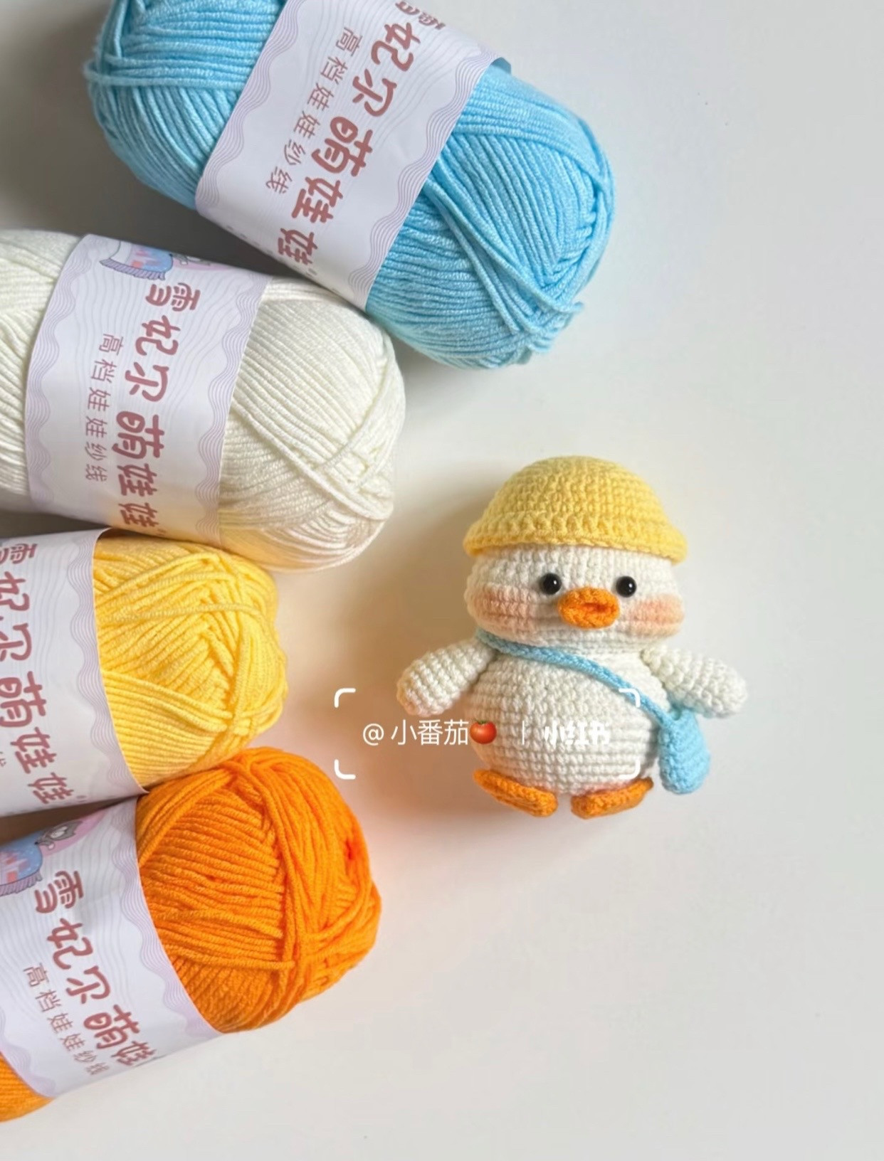 Chú vịt len nhỏ xinh đội mũ vàng cầm túi xanh