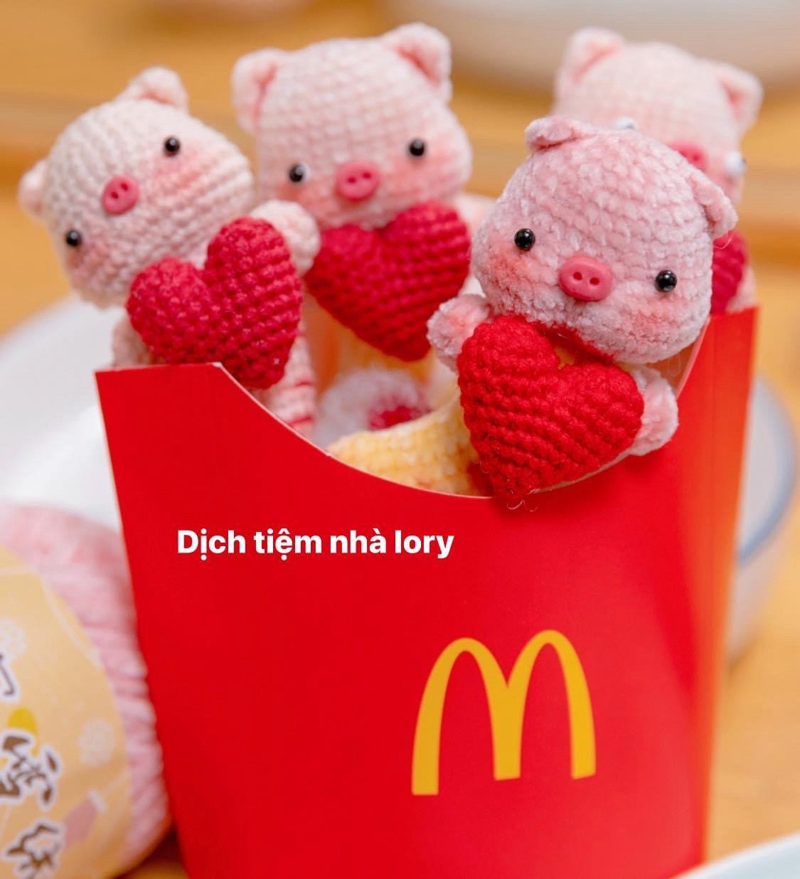 Hai chú heo móc len cầm trái tim trong tay