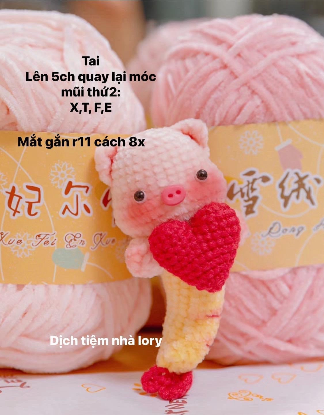 Hai chú heo móc len cầm trái tim trong tay