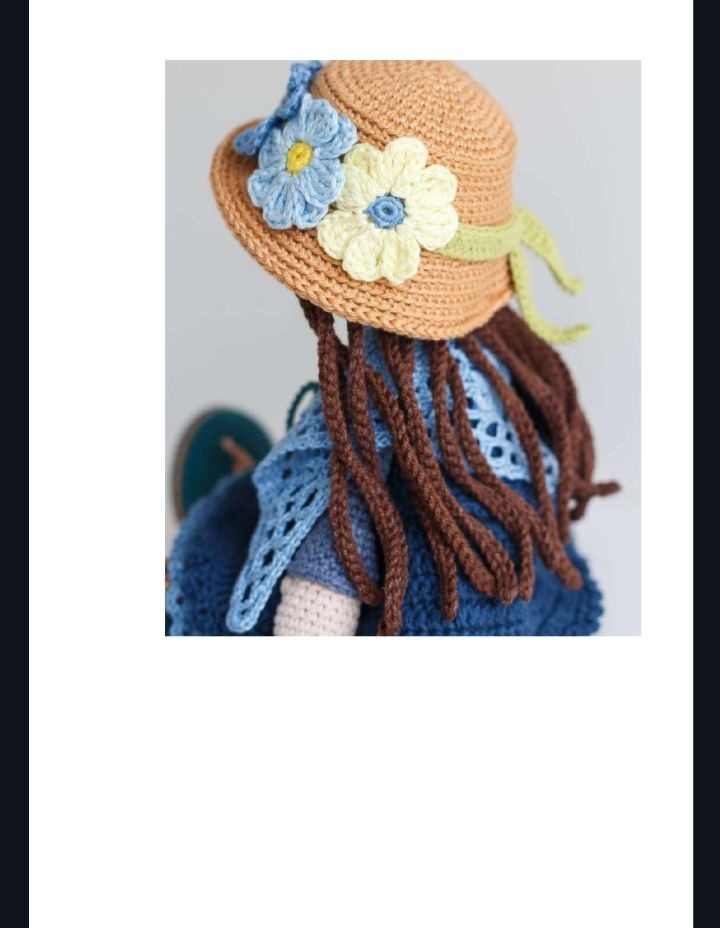 Muñeca de ganchillo con vestido azul y sombrero de flores