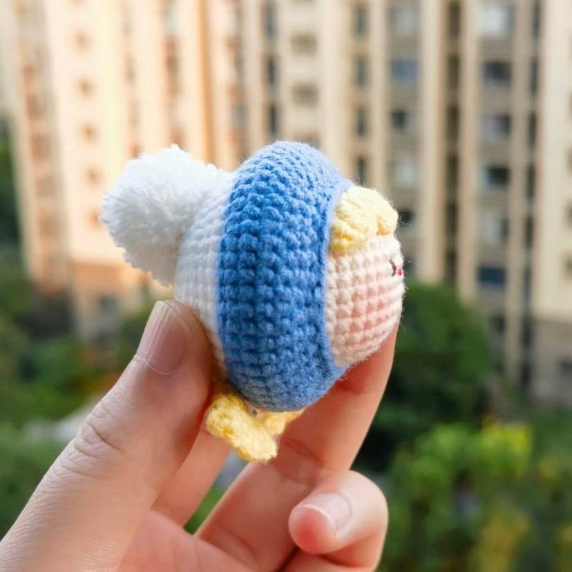 Búp bê béo tròn dễ thương với bộ đồ len xanh và tóc vàng