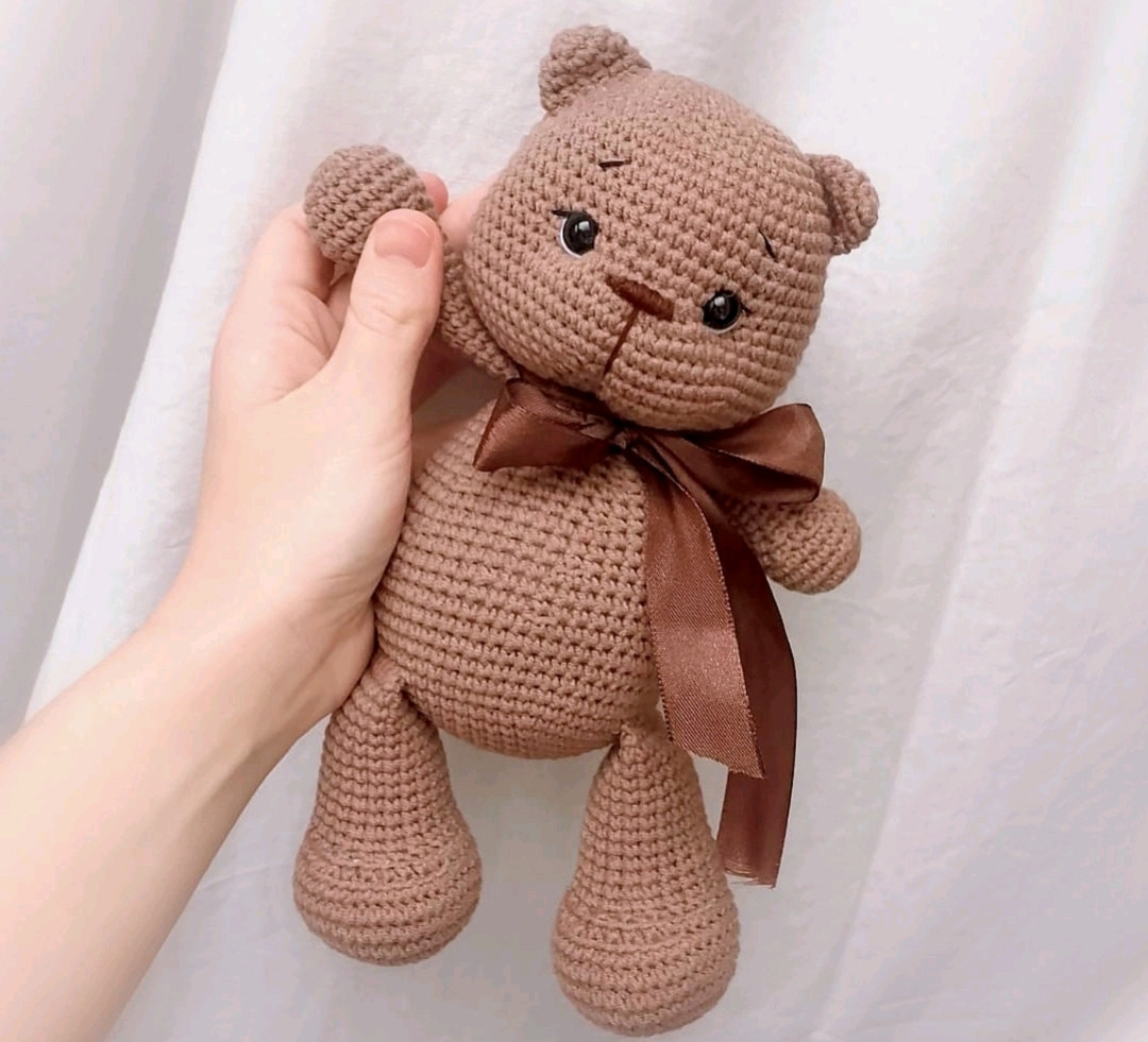 В'язані гачком іграшкові ведмедики у кошику з бантами