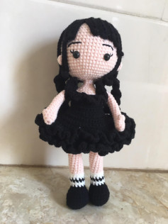 Mẫu móc búp bê bé gái với váy màu đen, tóc đen.