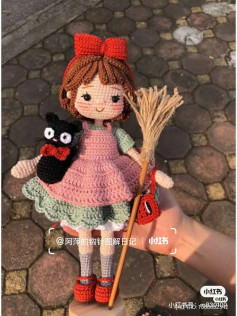 Brown hair doll crochet pattern, wearing a red bow and holding a broom