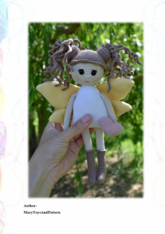 crochet doll with brown hair, white shirt and wings
