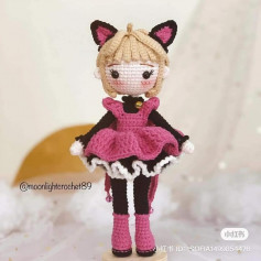 Knitted doll with blonde hair, wearing fox ears, wearing a pink dress.