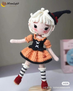 Woolen doll crochet pattern with white hair, orange skirt, black shirt.